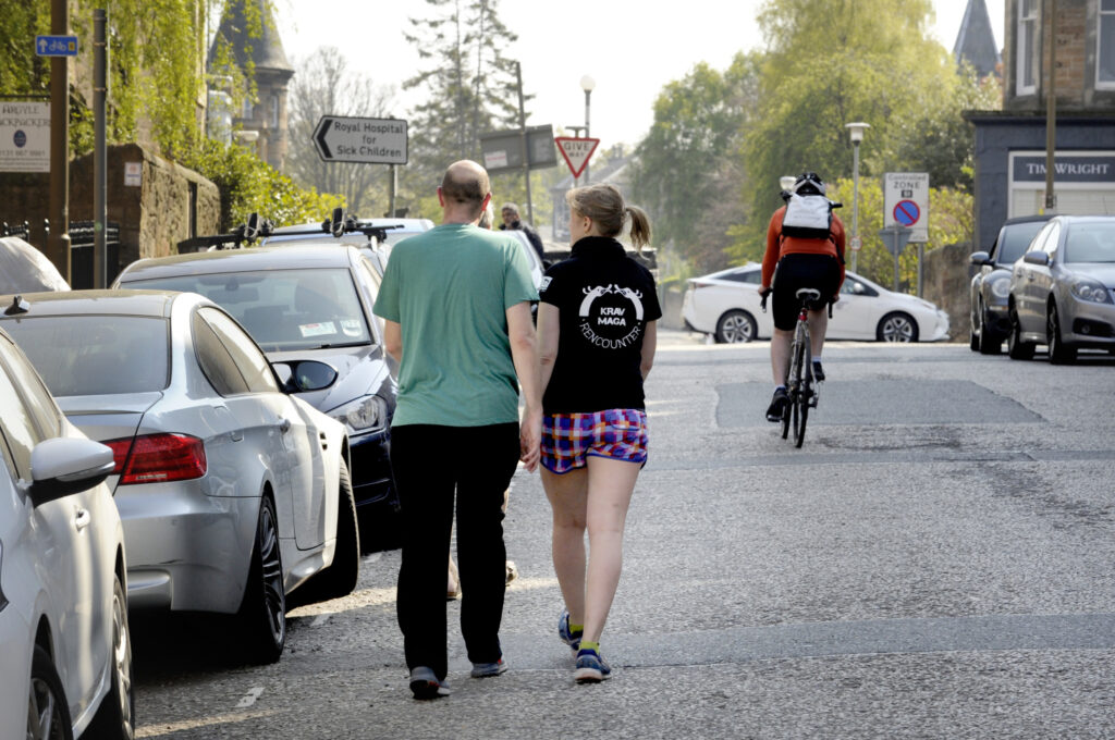 Two people walk along a road 