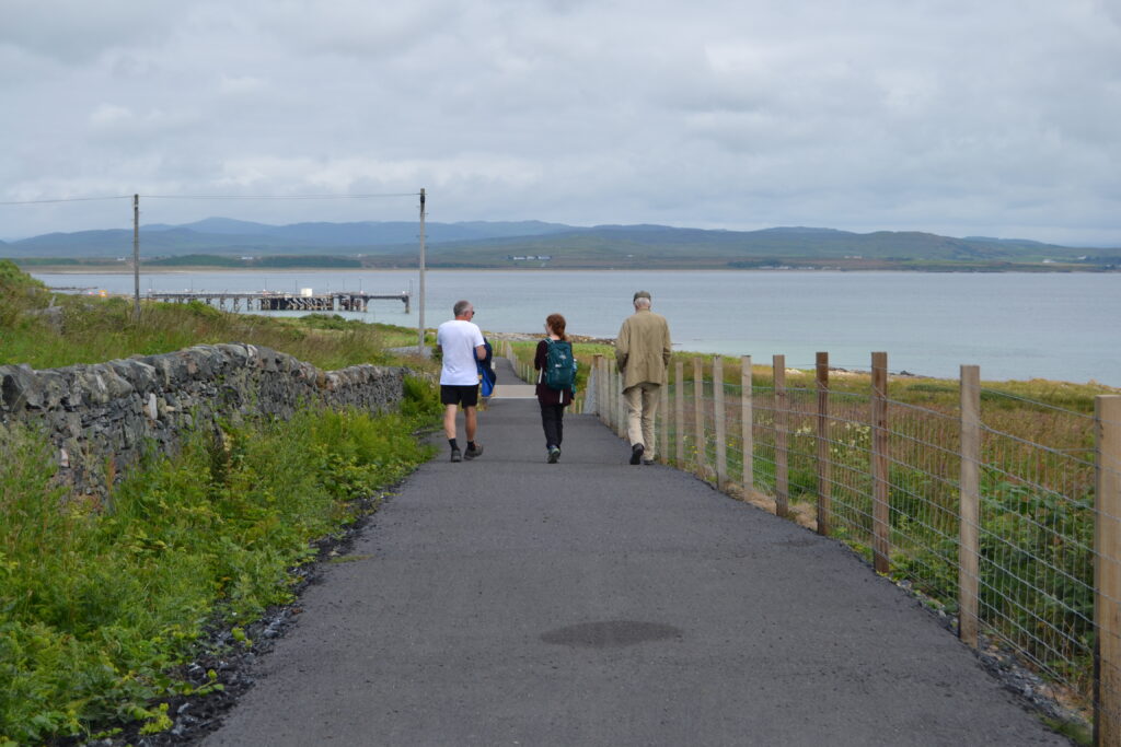 3 figures walking along the Loch Indaal Way.