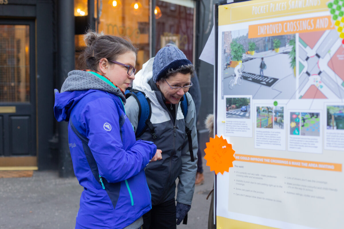 Sustrans Scotland Pocket Places engagement in Shawlands, Glasgow.. A Sustrans officer and a member of the public looking at an information board.