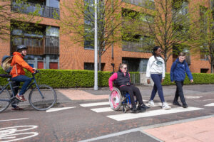 People walking and wheeling on the South City Way in Glasgow.