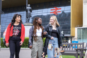 Group of young women using busy city centre public space and station access