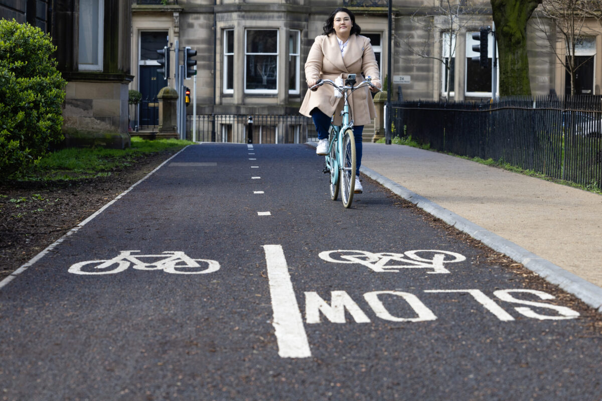 Cyclist cycles towards camera on cycle lane
