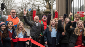 Cheering children and adults holding red tape