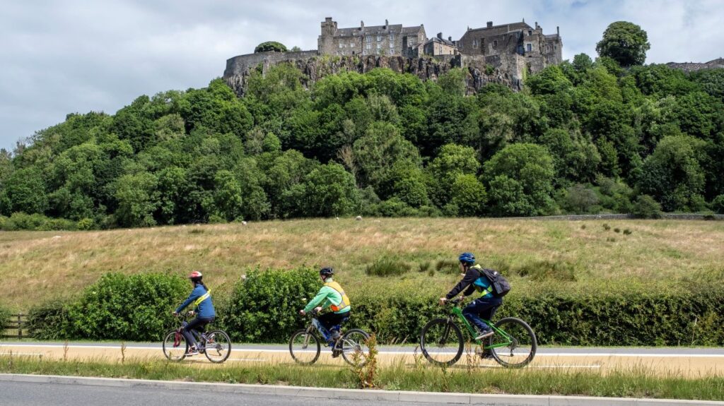 Young people cycling on segregated infrastructure on Dumbarton Road with Stirling Castle in the background